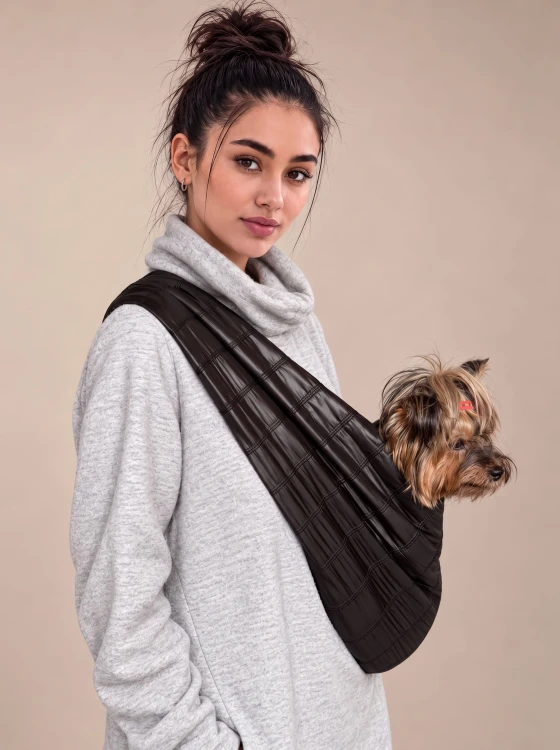 Yorkshire terrier w czarnym nosidle dla psa na ramię.