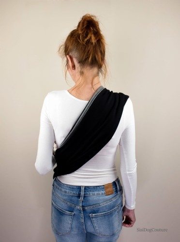 Kobieta niesie kota w miękkim nosidle typu sling